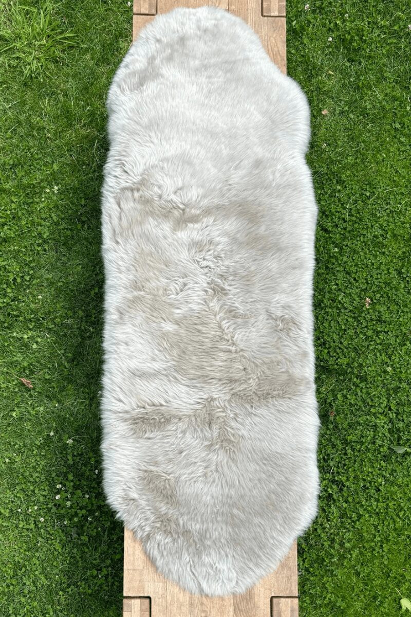 Sitzauflage aus Schaffell für Outdoor Lammfell in platingrau auf Bank