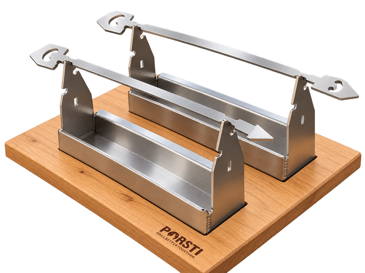 Zwei metallene Grillspieße auf passenden Halterungen mit Auffangrinnen, auf einem Holzbrett mit PORSTI-Logo