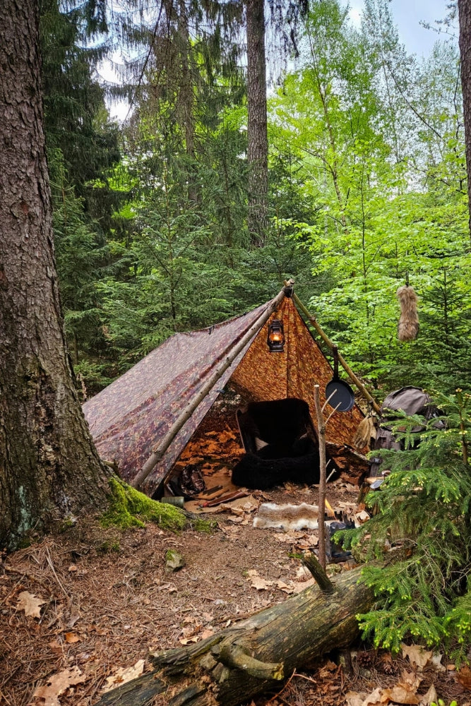 DD Hammocks Tarp 3 x 3 m in Multicam als A-Frame über dem Lagerplatz aufgebaut