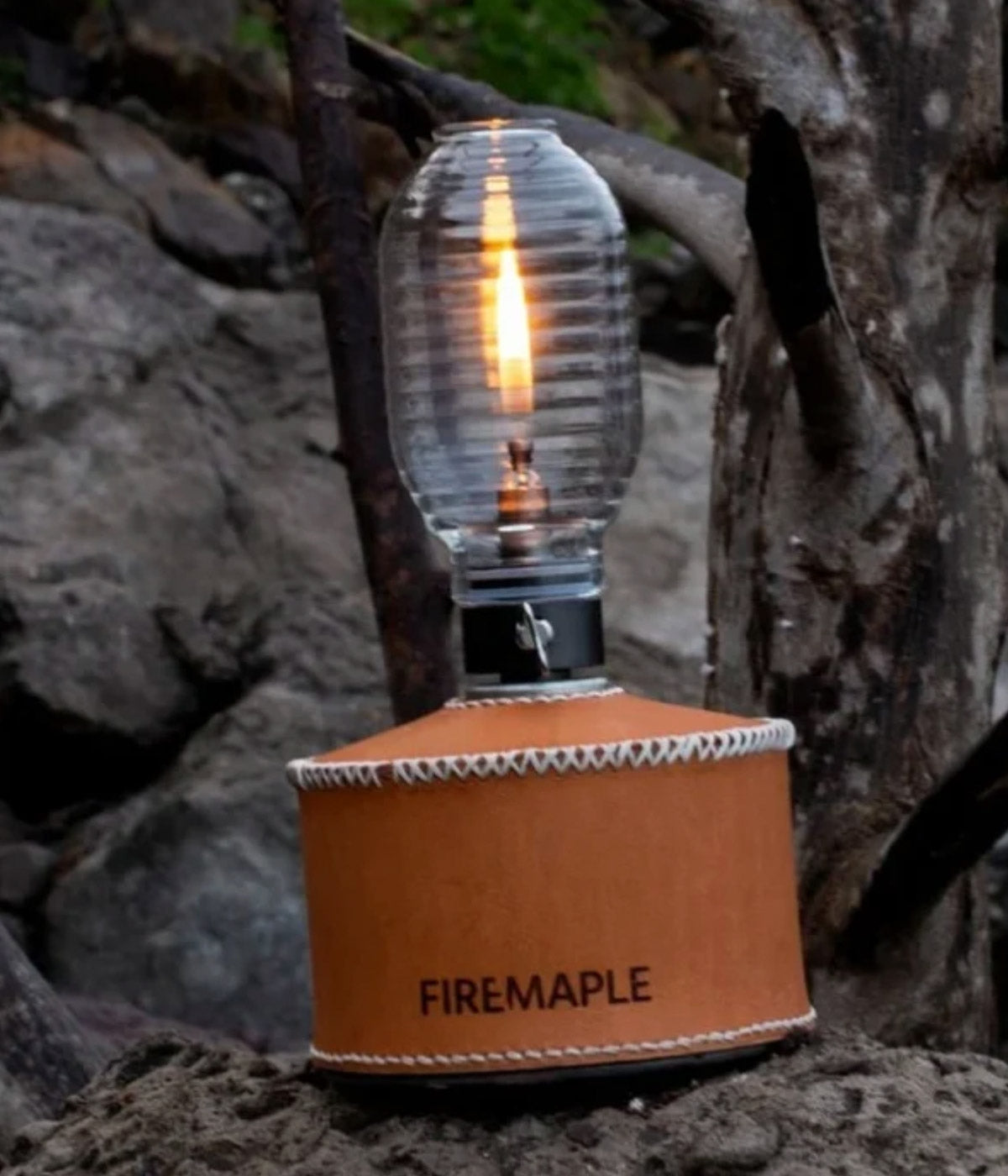 Firemaple Firefly Gaslaterne mit Ledermantel leuchtet auf einem Felsen im Wald