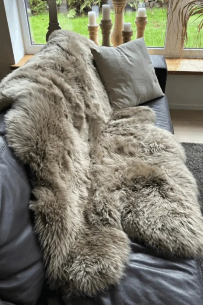 Gemütliches XXL Lammfell als Sofa-Dekoration – natürliches Fell für Wärme und Wohnkomfort.