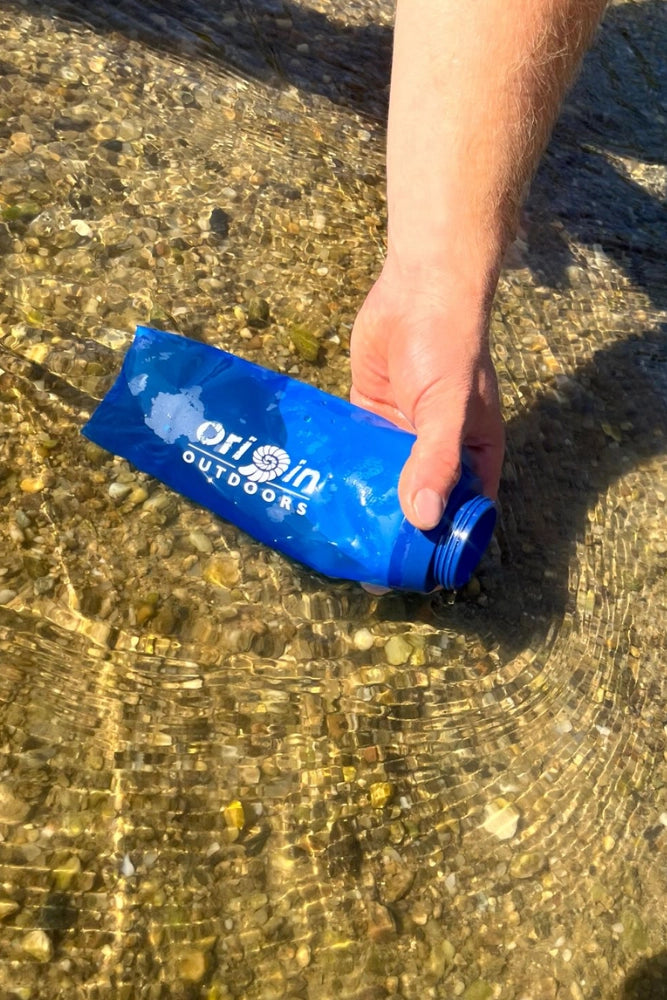 Origin Outdoors Dawson beim Befüllen mit Wasser aus einem Fluss