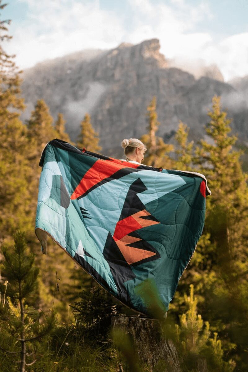 Campingdecke WANDA Sherpa von Campo Libre peaks'n'valleys Frau im Wald mit Decke