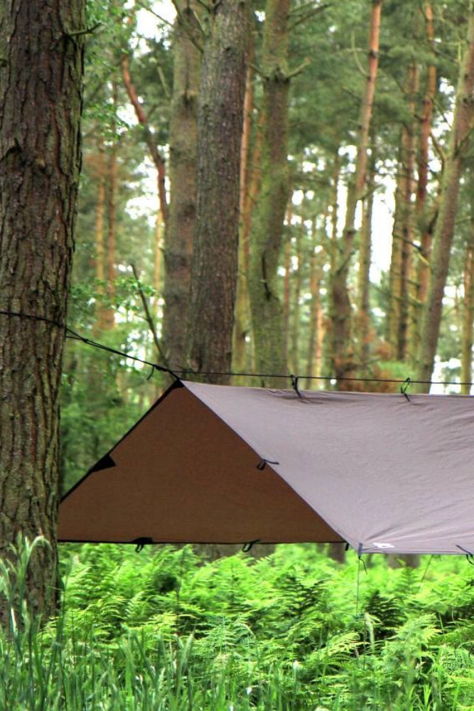DD Hammocks Tarp 3 x 3 m in Coyote Braun im Wald über dem Lagerplatz aufgebaut