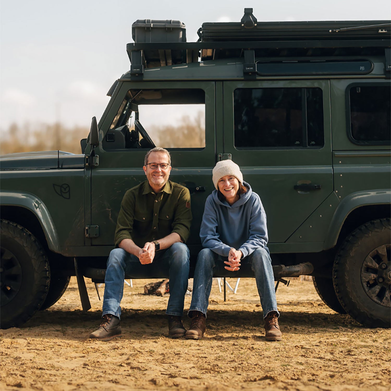 Lars und Kerstin, die Gründer von Fritz & Frei, draußen vor ihrem grünen Geländewagen