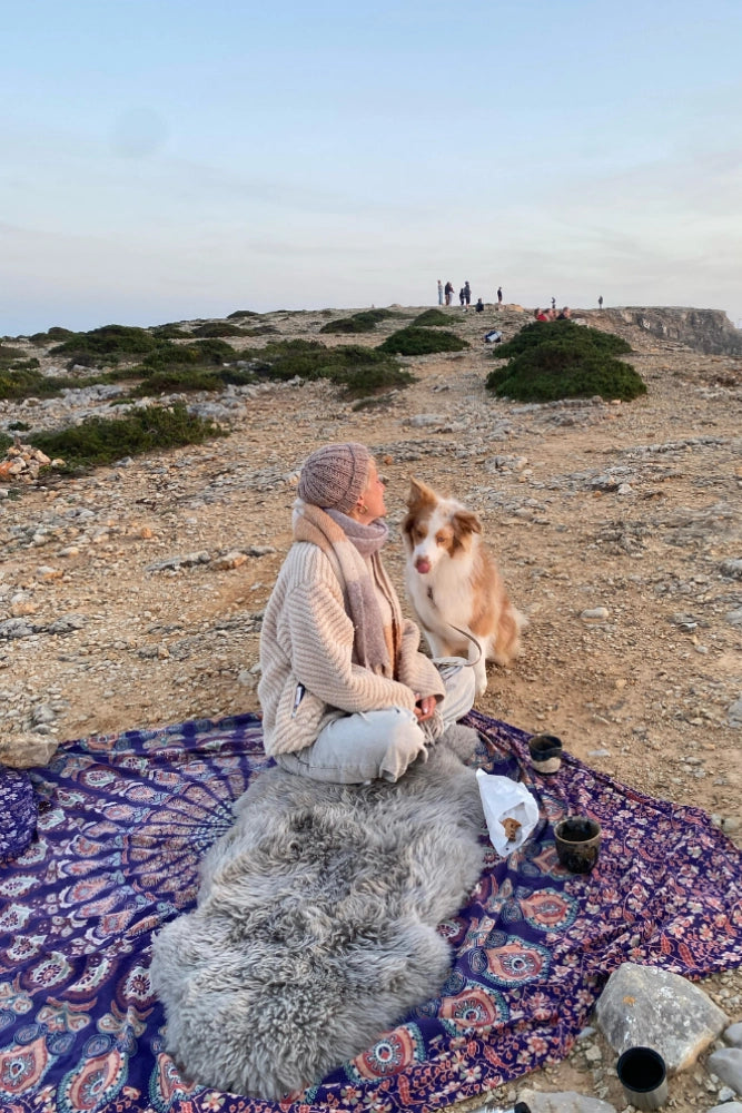 Fritz und Frei Merinofell beim Camping am Strand als weiche Sitzunterlage im Sand für gemütliche Pausen