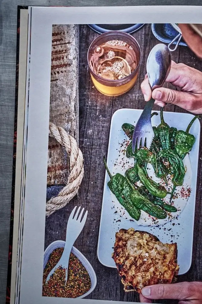 Kochen unter freiem Himmel Buch aufgeklappt mit Rezepten fuer Outdoor Camping und Lagerfeuer Kueche