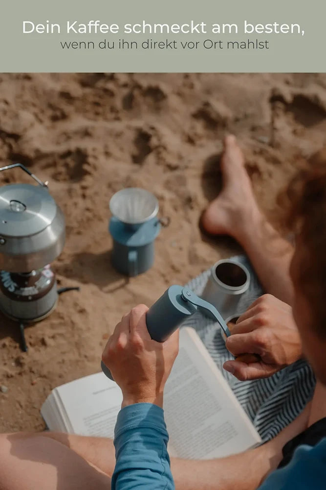 Lambda Coffee Kaffeemühle Terra in Dusk Blue am Strand – manuelle Edelstahl-Handmühle für Outdoor, Reisen und Vanlife