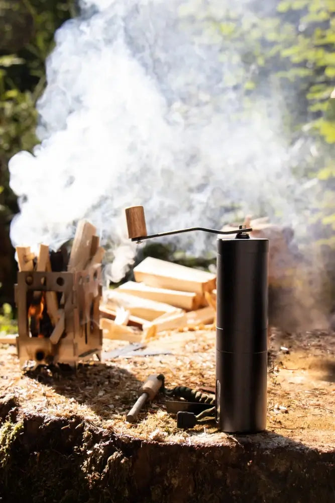 Lambda Coffee Kaffeemühle Terra in Nautic Night im Einsatz am Lagerfeuer – manuelle Outdoor-Kaffeemühle für Camping und Vanlife