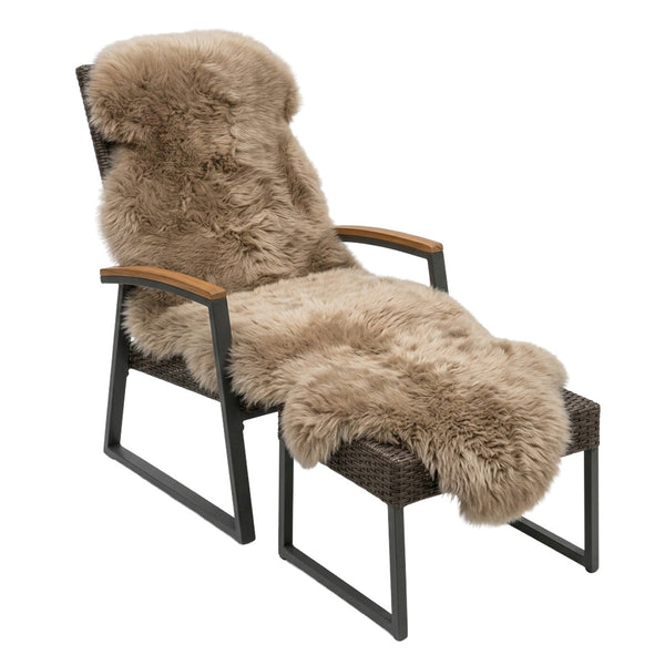 Merino Schaffell Größe XL mit 180 x 65 cm auf einem Sessel mit Fußablage