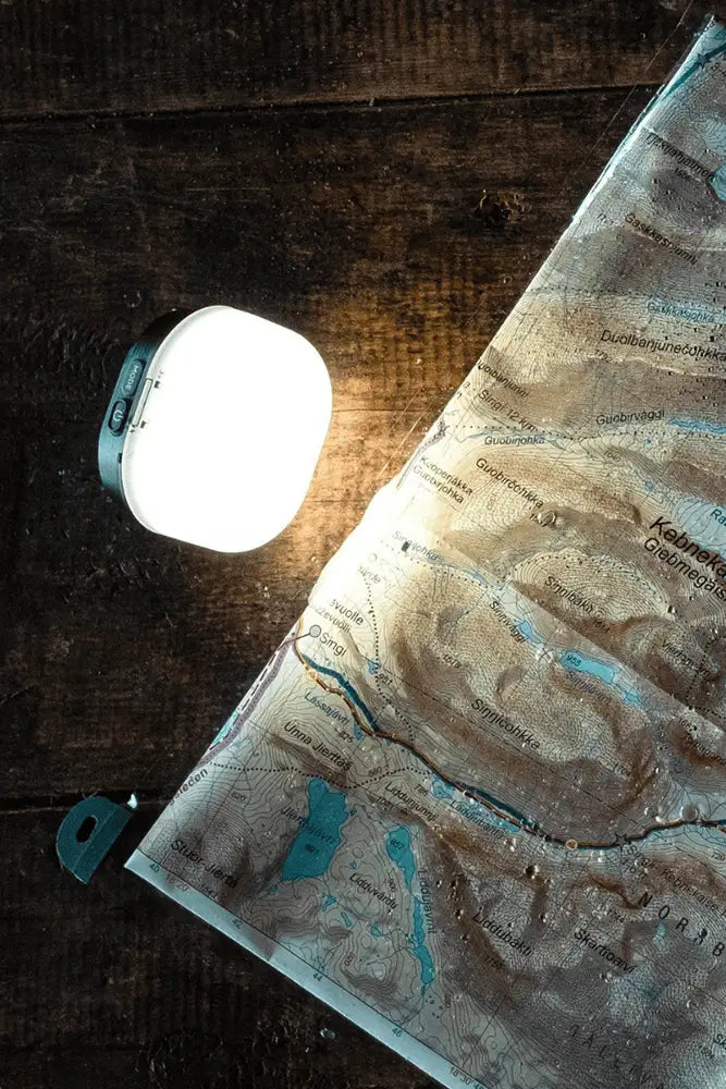 Primus Glow Recharge Campinglampe beim Wandern im Wald mit warmem Abendlicht im Outdoor Einsatz